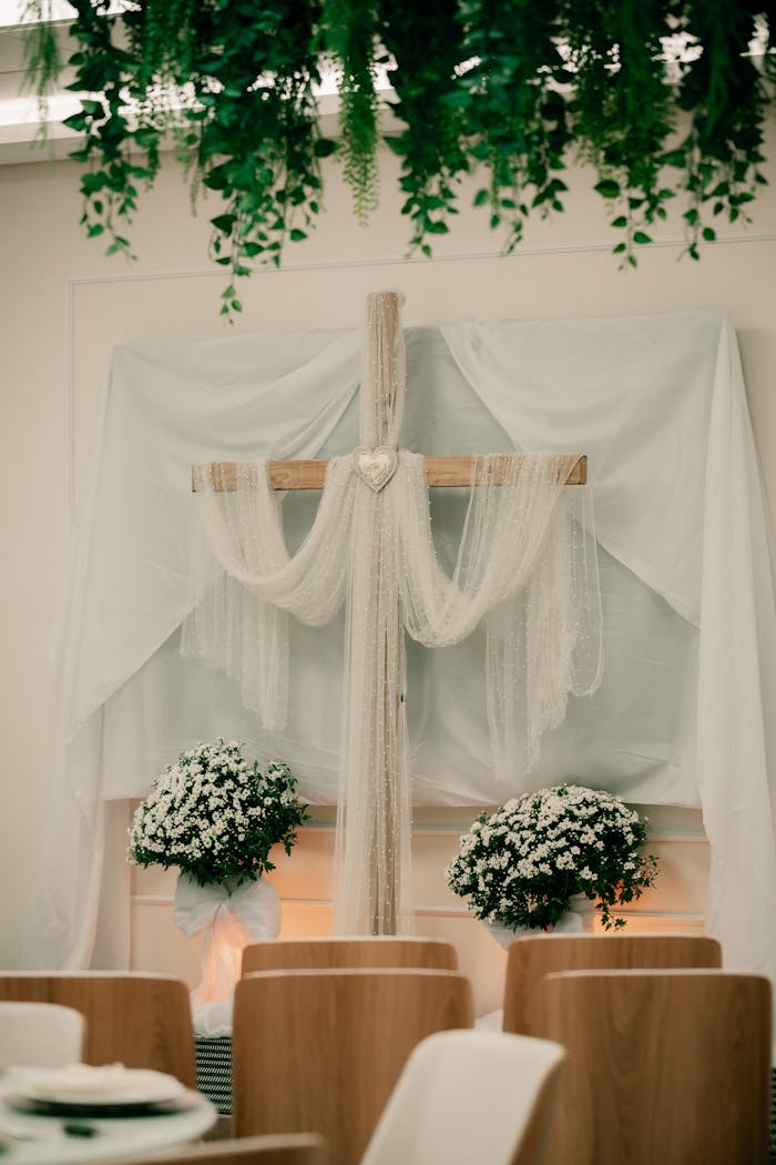 Beautifully decorated indoor wedding venue with floral and cross arrangements.